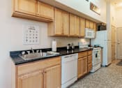 Thumbnail 18 of 29 - A kitchen with wooden cabinets and a white fridge.