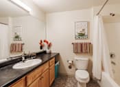 Thumbnail 21 of 29 - A bathroom with a white toilet, sink, and shower.