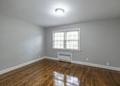 Thumbnail 11 of 12 - A room with a window and a radiator on the floor.