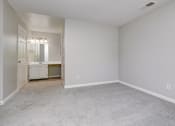 Thumbnail 21 of 41 - a bedroom with white walls and carpet and a bathroom at Boulder Pointe Apartments in Middletown, NY 10940
