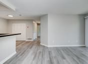 Thumbnail 13 of 41 - an empty living room and kitchen with wood flooring and a large window at Boulder Pointe Apartments in Middletown, NY 10940