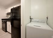 Thumbnail 4 of 41 - a white washer and dryer in a kitchen with a black refrigerator at Boulder Pointe Apartments in Middletown, NY 10940