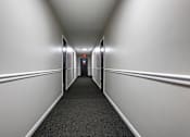 Thumbnail 13 of 17 - A long, narrow hallway with a red light at the end.