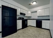 Thumbnail 5 of 17 - A kitchen with black appliances and white cabinets.