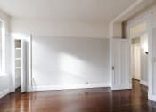 Thumbnail 14 of 23 - an empty room with a hard wood floor and white walls