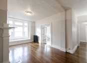 Thumbnail 8 of 23 - an empty living room with wood floors and a large window