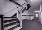 Thumbnail 20 of 23 - a stairwell in a building with a metal railing and carpeted floors