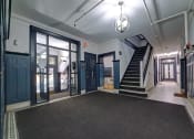 Thumbnail 17 of 23 - the lobby of a building with blue doors and a staircase