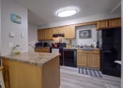 Thumbnail 13 of 45 - Kitchen with wooden cabinets and a counter top at Cedar Park Apartments, Troy