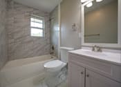 Thumbnail 11 of 28 - A white bathroom with a marble tiled shower.