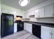 Thumbnail 6 of 47 - a kitchen with white cabinets and black appliances