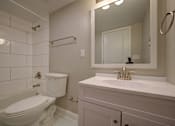 Thumbnail 14 of 55 - A white toilet sits next to a white sink in a bathroom.