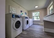 Thumbnail 29 of 34 - A laundry room with two washing machines and a window.