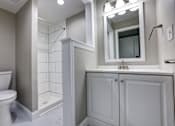 Thumbnail 5 of 34 - A white toilet sits next to a white sink in a bathroom.