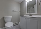 Thumbnail 6 of 34 - A white toilet sits next to a white sink in a bathroom.