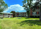 Thumbnail 3 of 38 - a grassy area with trees and buildings in the background