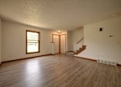 Thumbnail 11 of 33 - A room with wooden floors and a staircase leading to another room.
