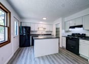 Thumbnail 6 of 33 - an empty kitchen with black appliances and white cabinets