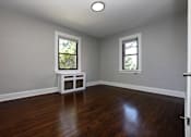 Thumbnail 7 of 10 - A room with a white bench and two windows.
