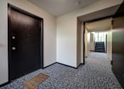 Thumbnail 11 of 44 - A hallway with a carpeted floor and a door on the left.  at Highland Club Apartments, Watervliet, NY 12189