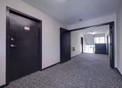 Thumbnail 11 of 44 - a hallway with a black door and a staircase in a building at Highland Club apartments, Watervliet, NY 12189