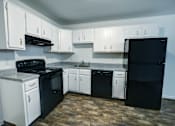 Thumbnail 9 of 21 - A kitchen with black and white appliances and cabinets.