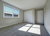 Thumbnail 15 of 30 - A room with a large window and two doors.
