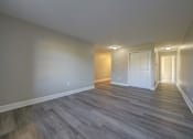 Thumbnail 14 of 30 - A room with a wooden floor and white walls.