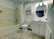 Thumbnail 10 of 21 - A white bathroom with a toilet, sink, and tub.