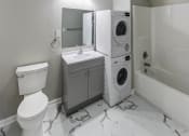 Thumbnail 9 of 33 - a white bathroom with a washing machine and a toilet and a sink