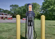 Thumbnail 31 of 33 - a gas pump sitting in the grass next to some yellow poles