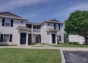 Thumbnail 19 of 33 - an apartment building with white siding and a sidewalk