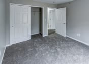 Thumbnail 14 of 33 - an empty bedroom with white doors and a carpeted floor