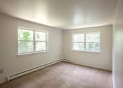 Thumbnail 16 of 30 - a small bedroom with two windows and a carpeted floor