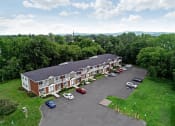 Thumbnail 1 of 30 - an aerial view of a red brick building with a gray roof and a parking lot in front