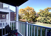 Thumbnail 27 of 38 - A chair is on a porch with a view of trees.