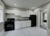 Thumbnail 5 of 27 - A kitchen with black appliances and white cabinets.