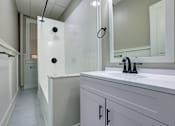 Thumbnail 8 of 27 - A white bathroom with a white sink and a white cabinet.