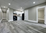 Thumbnail 6 of 27 - A kitchen with a black oven and white cabinets.