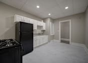 Thumbnail 4 of 27 - A kitchen with a black refrigerator and a black stove top at Willett Apartments, Albany, New York