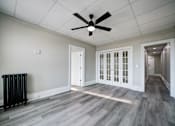 Thumbnail 18 of 27 - Unfurnished room with white door and fan at Willett Apartments, Albany, New York