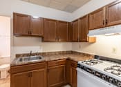 Thumbnail 6 of 27 - Kitchen with white stove at Willett Apartments, Albany, NY, 12210