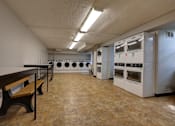 Thumbnail 20 of 25 - A kitchen with a table and benches and ovens.
