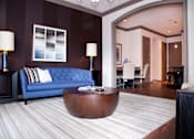 Thumbnail 3 of 17 - a living room with a blue couch and a coffee table