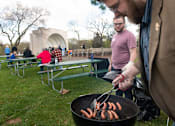 Thumbnail 10 of 11 - a group of men grilling hot dogs on a grill
