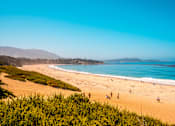 Thumbnail 22 of 30 - A beach with people enjoying the sun and sand.