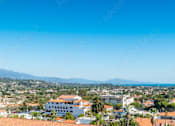Thumbnail 18 of 30 - A coastal cityscape with buildings and a clear blue sky.
