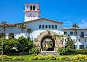 Thumbnail 15 of 30 - A white building with a clock tower and a large archway entrance.