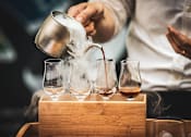 Thumbnail 1 of 6 - a man in a white shirt pours whisky into glasses in a wooden box