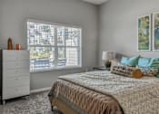 Thumbnail 6 of 16 - a bedroom with a bed and a large window